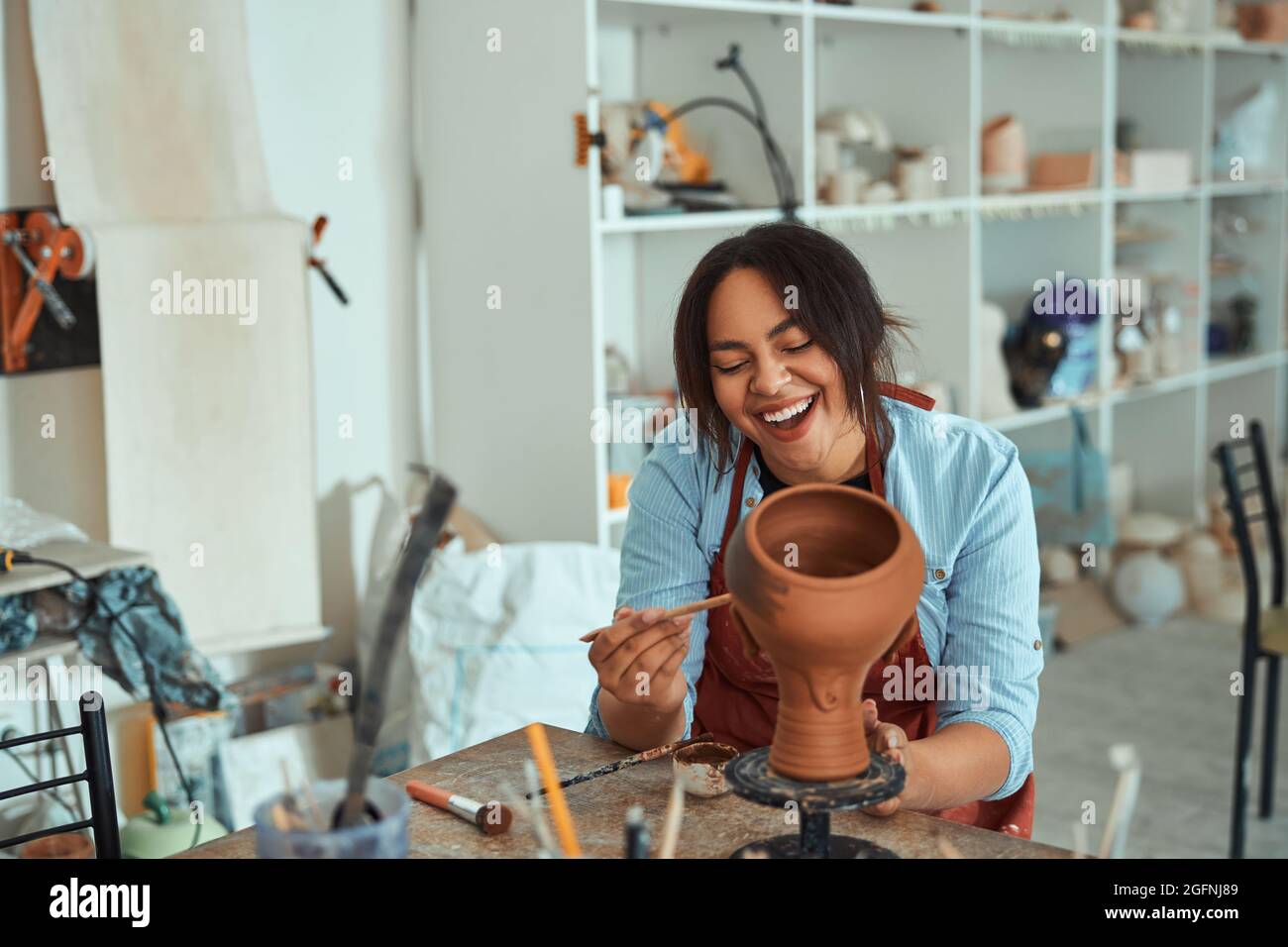 Smiling young woman working in art pottery studio Stock Photo - Alamy