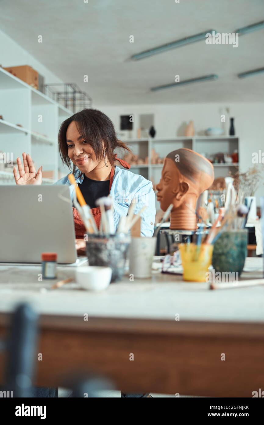 Charming female potter using notebook in pottery workshop Stock Photo