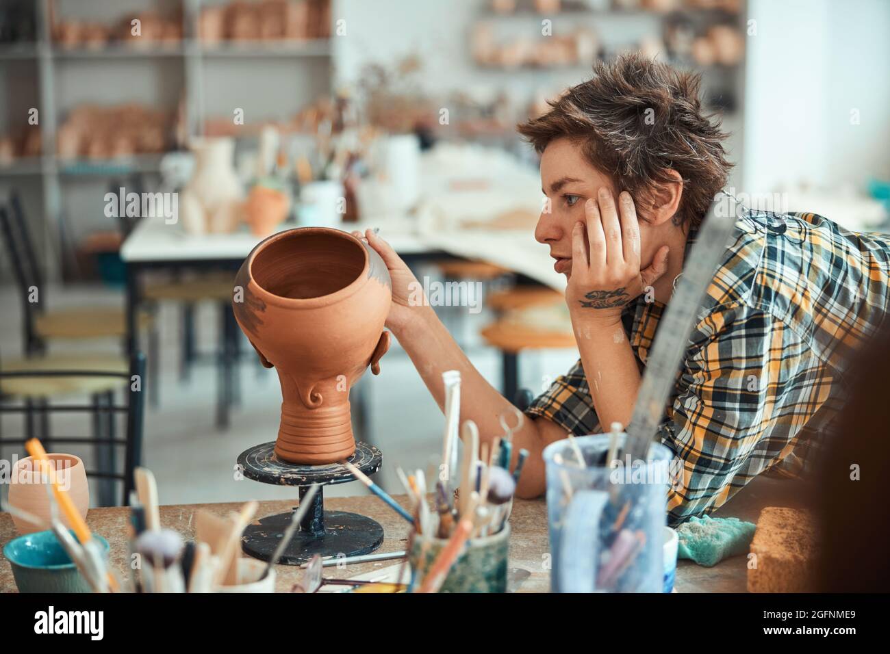 Charming female potter painting pottery in workshop Stock Photo - Alamy