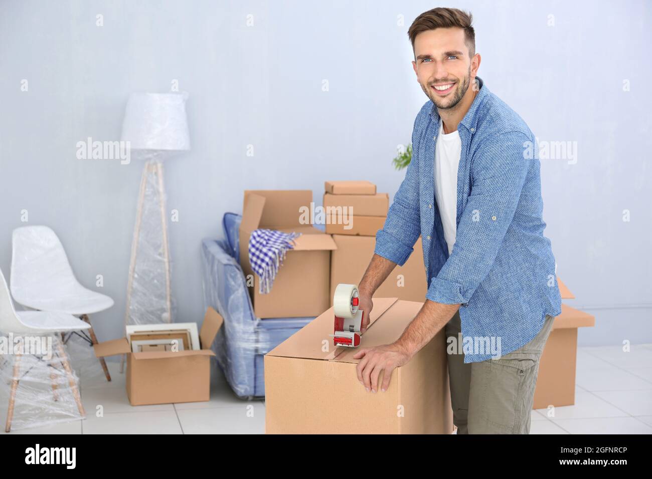 House moving concept. Man packing cardboard box Stock Photo - Alamy