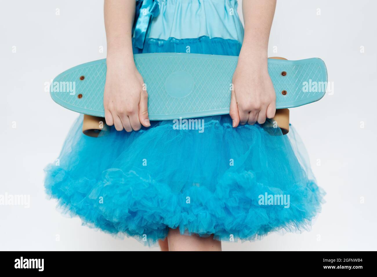 Close up teenager girl wearing blue fluffy skirt holding in hands a