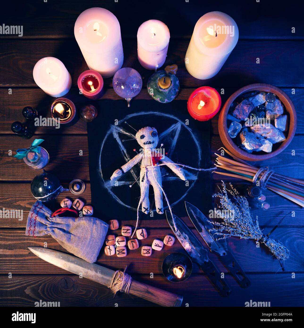 Creepy voodoo doll on dark scary spiritual wizardry table with candles and  magic attributes for halloween sorcery and curse Stock Photo - Alamy