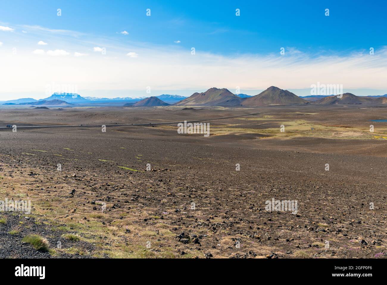 Impressive barren volcanic landscape crossed by a road on a clear summer day Stock Photo