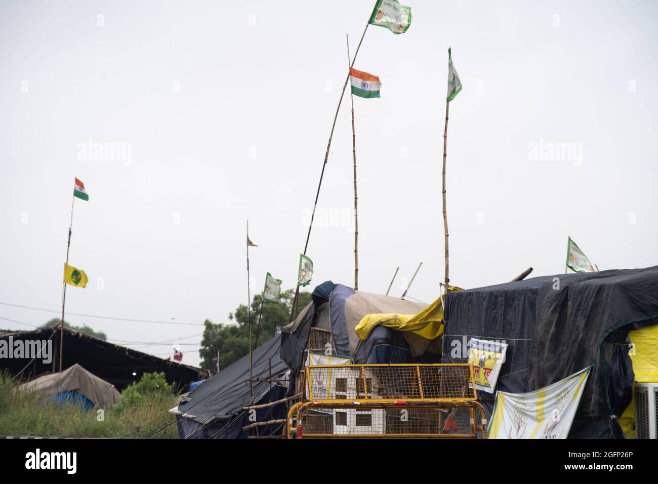 temporary tents with flags flying high with the farmer protest callout and india flag showing the abandoned protest sites in Delhi Stock Photo