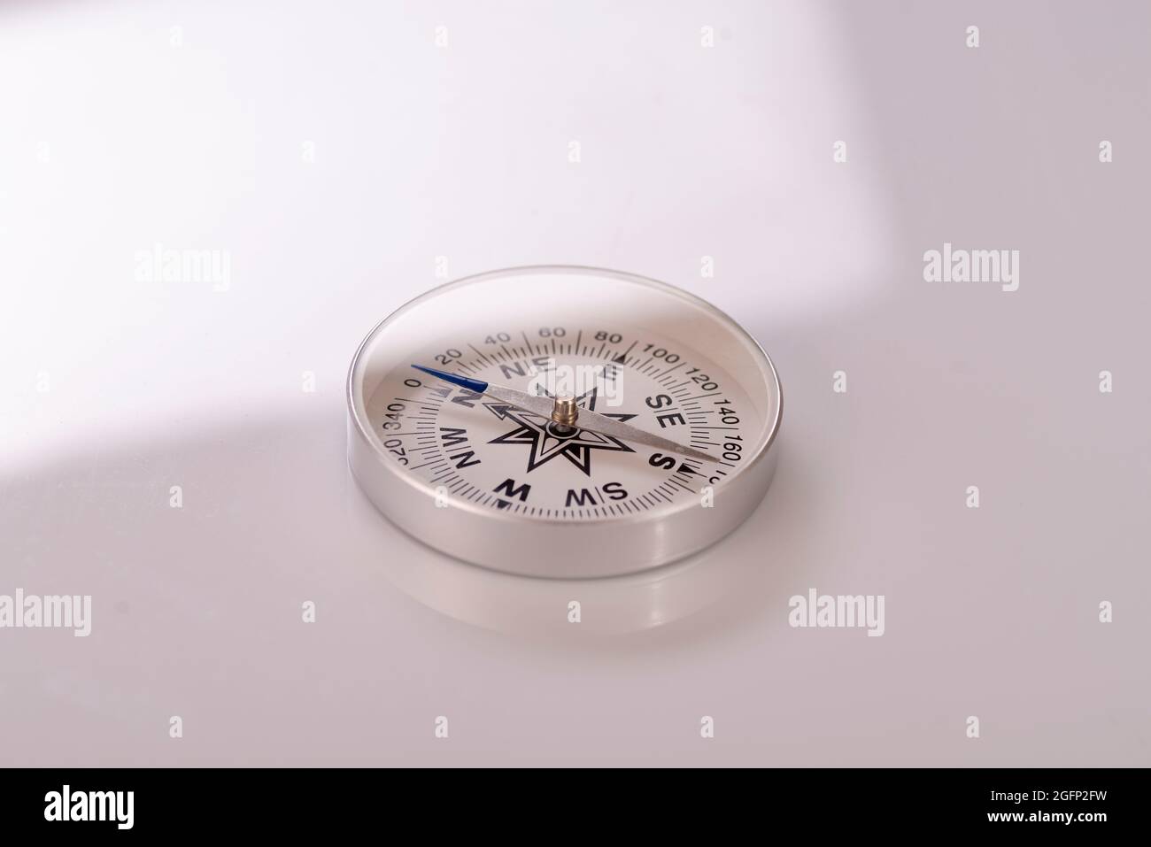 Compass on a white background. Sun glare compass. Stock Photo