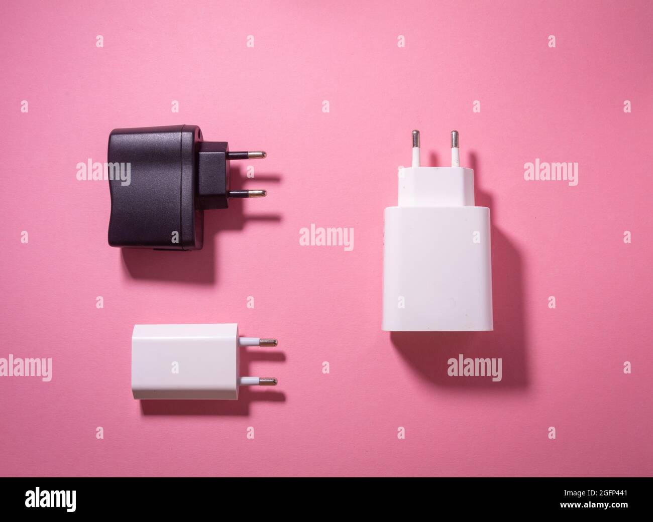white and black usb charging blocks on a pink background Stock Photo