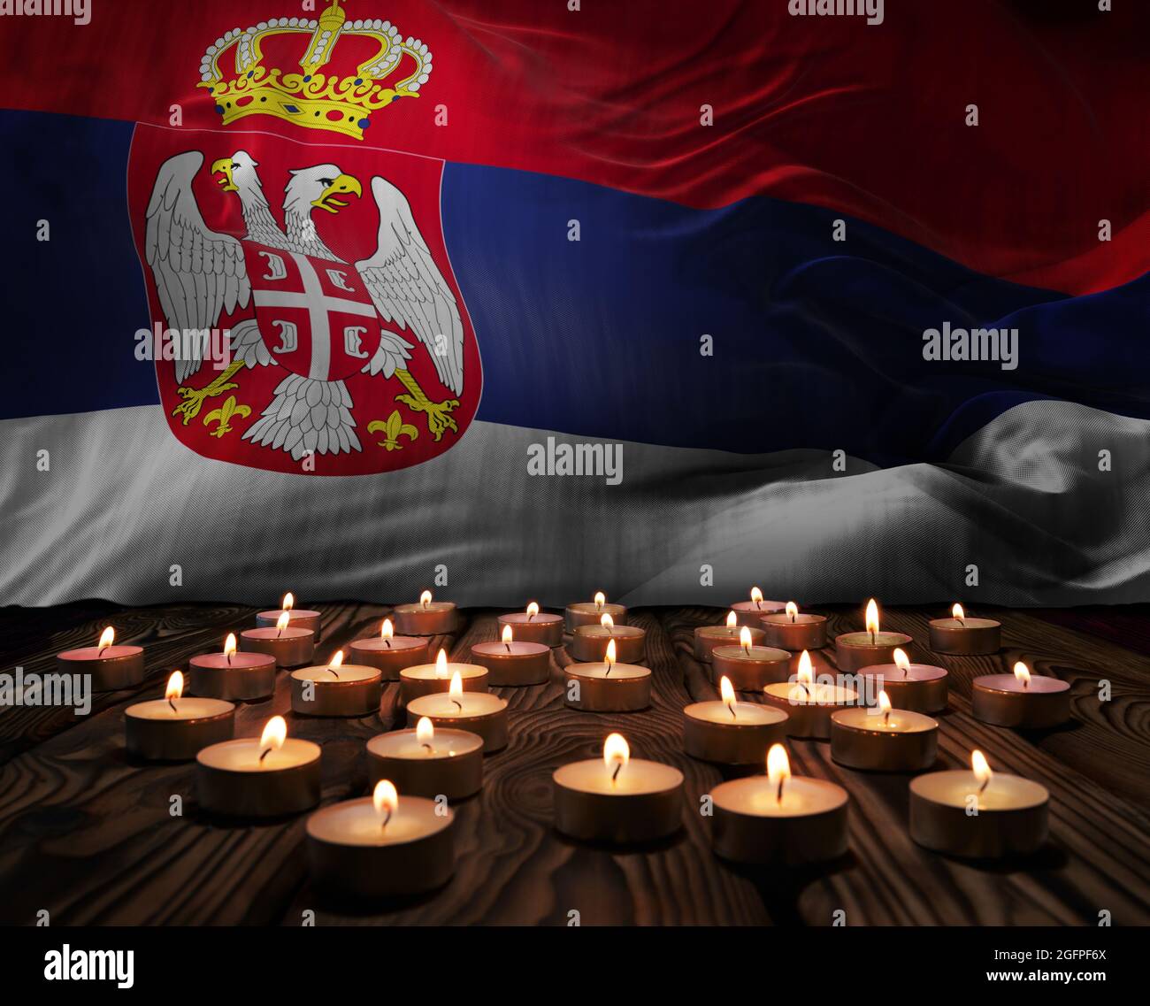 Mourning candles burning on Serbia national flag of background. Memorial weekend, patriot veterans day, National Day of Service Remembrance. Burning c Stock Photo