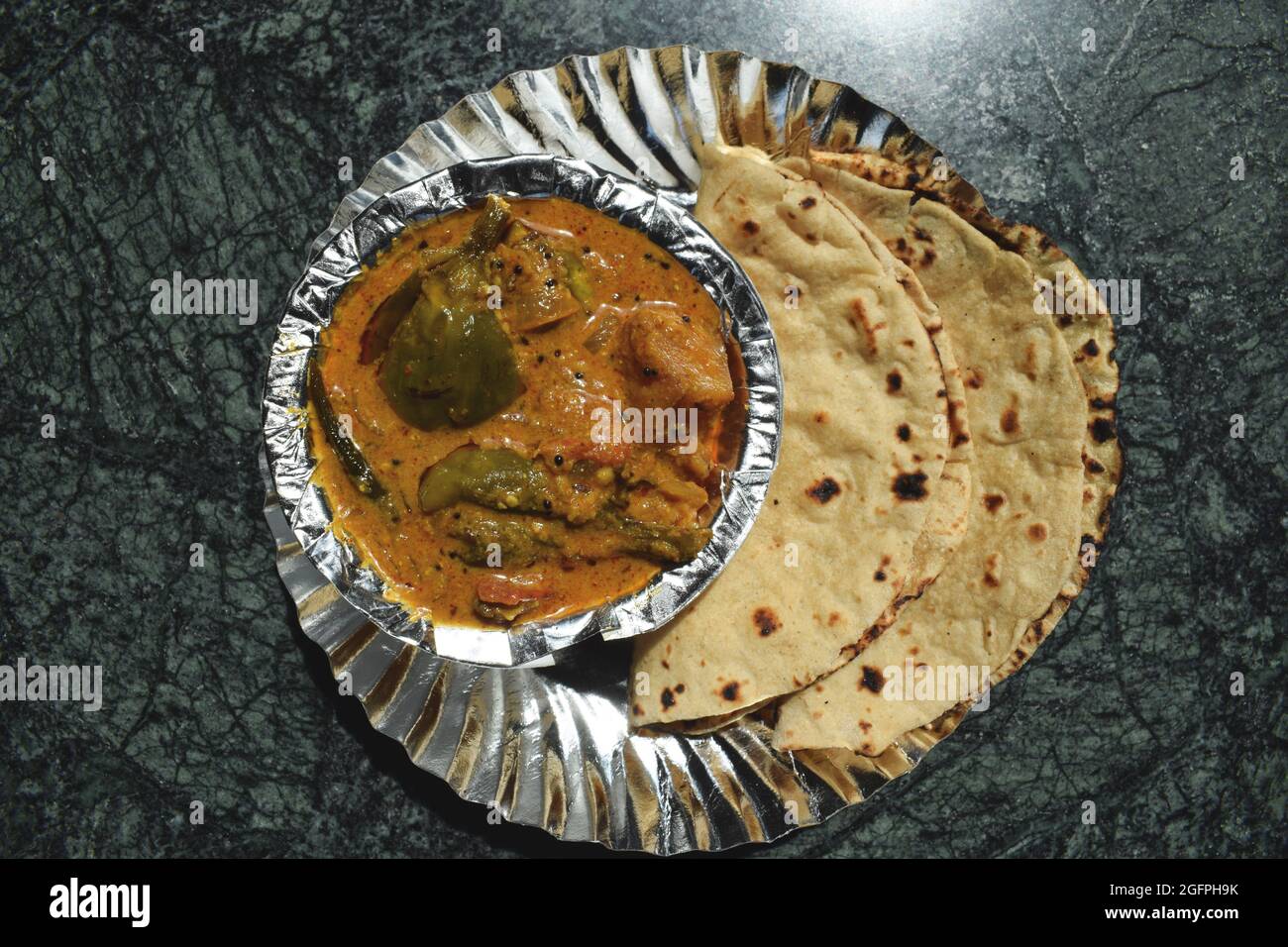 Indian home cooked dhaba style simple and traditional food Roti sabzi. Phulka with potato brinjal curry. Stock Photo