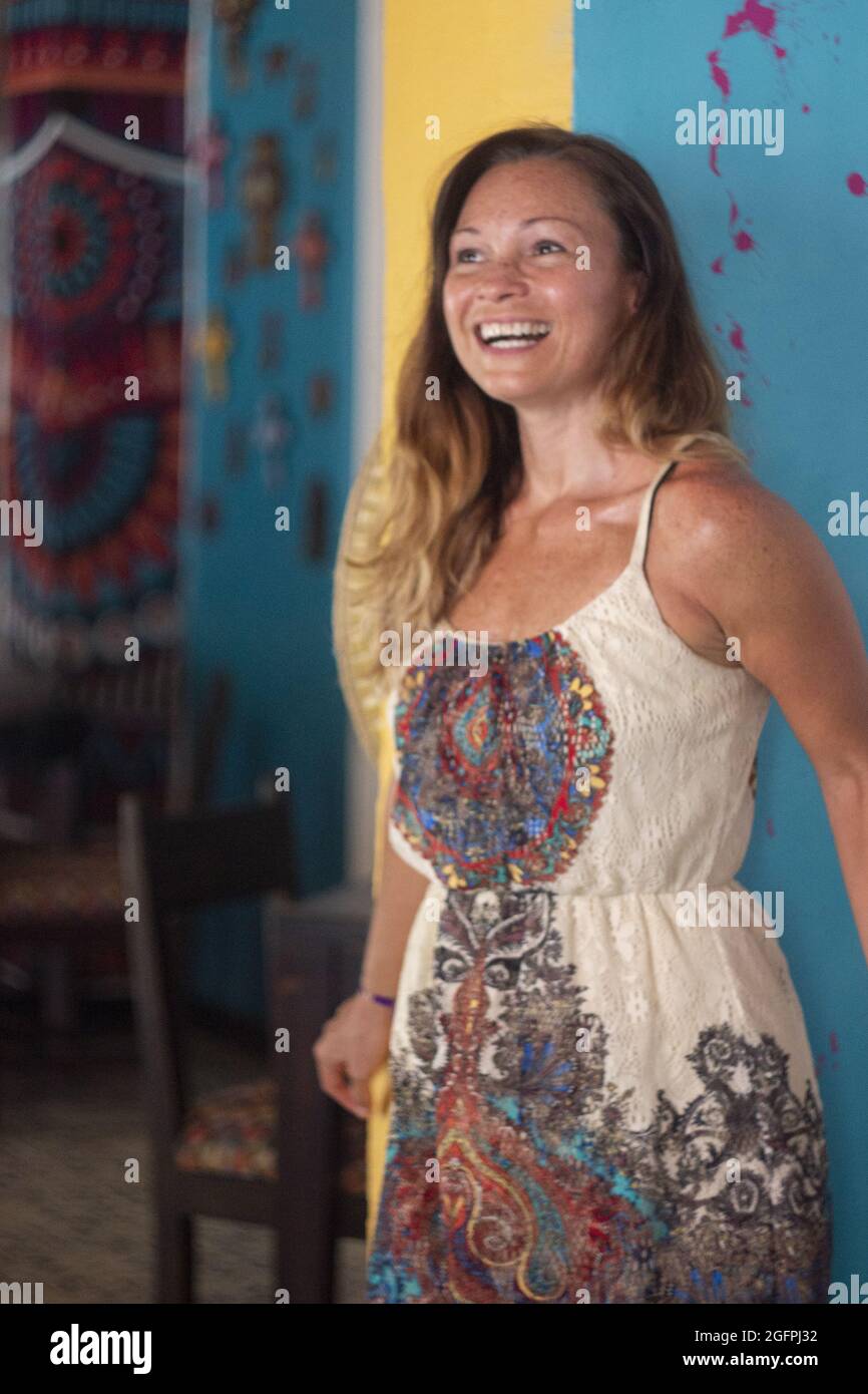 Vertical shot of a smiling Hispanic woman wearing a dress Stock Photo