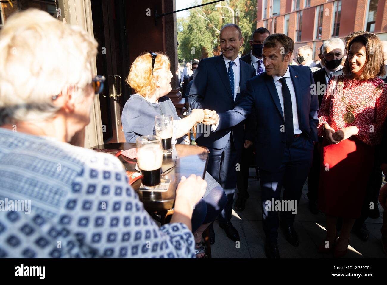 France President Emmanuel Macron, Irish Prime Minister Micheal Martin and Dublin Mayor Alison Gilliland speaks to people having a Guinness beer in a bar during a walkabout in the city centre after a meeting at the Goverment buildings in Dublin on August 26, 2021. Macron travelled to Ireland on August 26 for a one-day working visit. Photo by Raphael Lafargue/ABACAPRESS.COM. Stock Photo