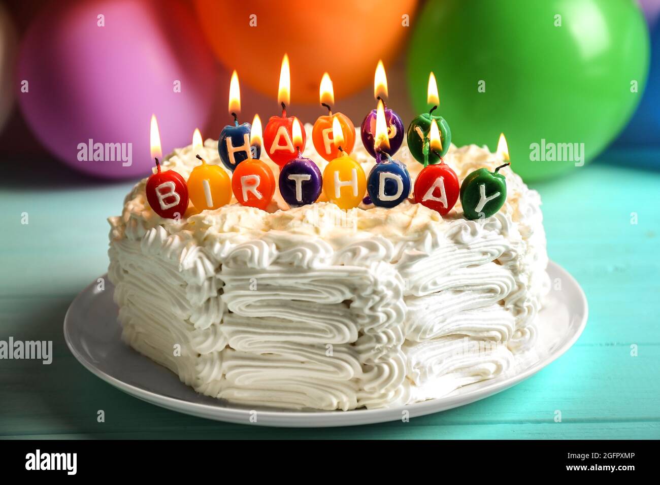Birthday cake with candles on balloons background Stock Photo - Alamy