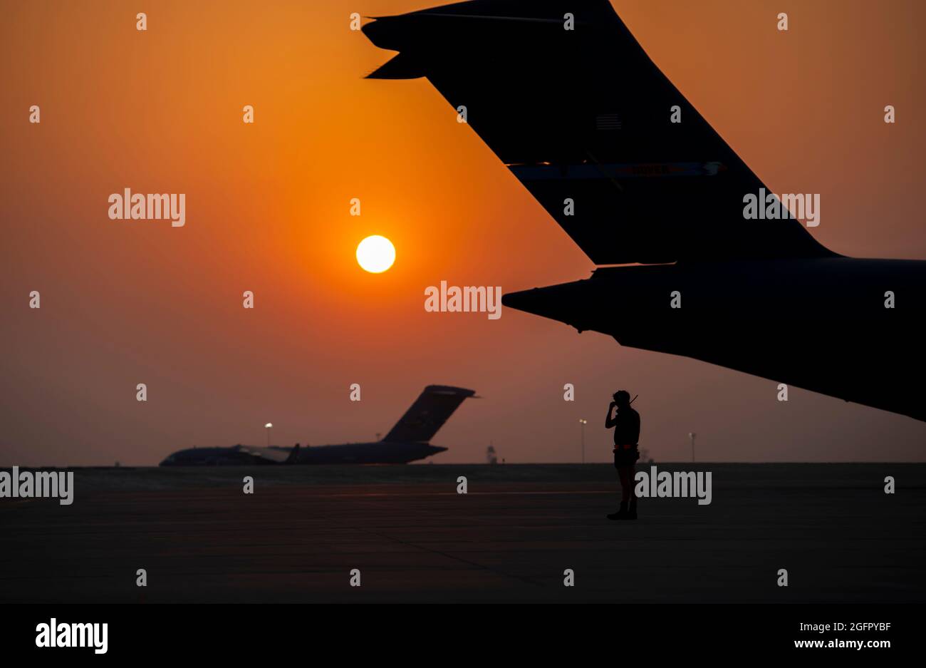 Al Udeied Air Base, Qatar. 23rd Aug, 2021. U.S. Air Force airman with the 379th Air Expeditionary Wing prepares to marshal a C-17 Globemaster lll aircraft as it taxis to the flight line for departure to Kabul in support of Operation Allies Refuge August 23, 2021 at Al Udeied Air Base, Qatar. Credit: Planetpix/Alamy Live News Stock Photo