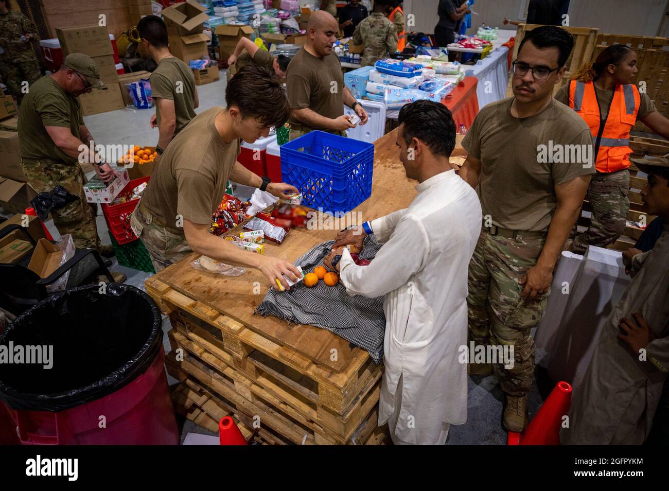 Al Udeied Air Base, Qatar. 23rd Aug, 2021. U.S. Air Force airmen provide food to Afghan refugees on arrival from Kabul August 23, 2021 at Al Udeied Air Base, Qatar. Credit: Planetpix/Alamy Live News Stock Photo