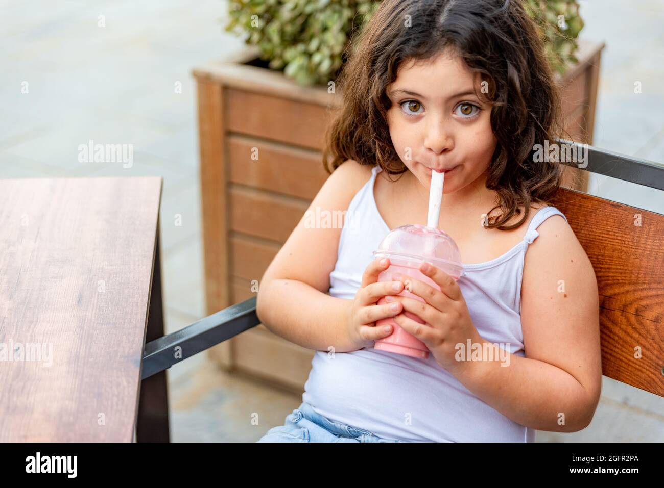 Сheerful african american young woman in summer dress and choker necklace  at cafe drinking milkshake cocktail Stock Photo - Alamy