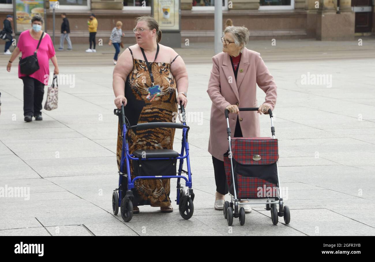 Obese woman, with an old lady, with walking aids Stock Photo