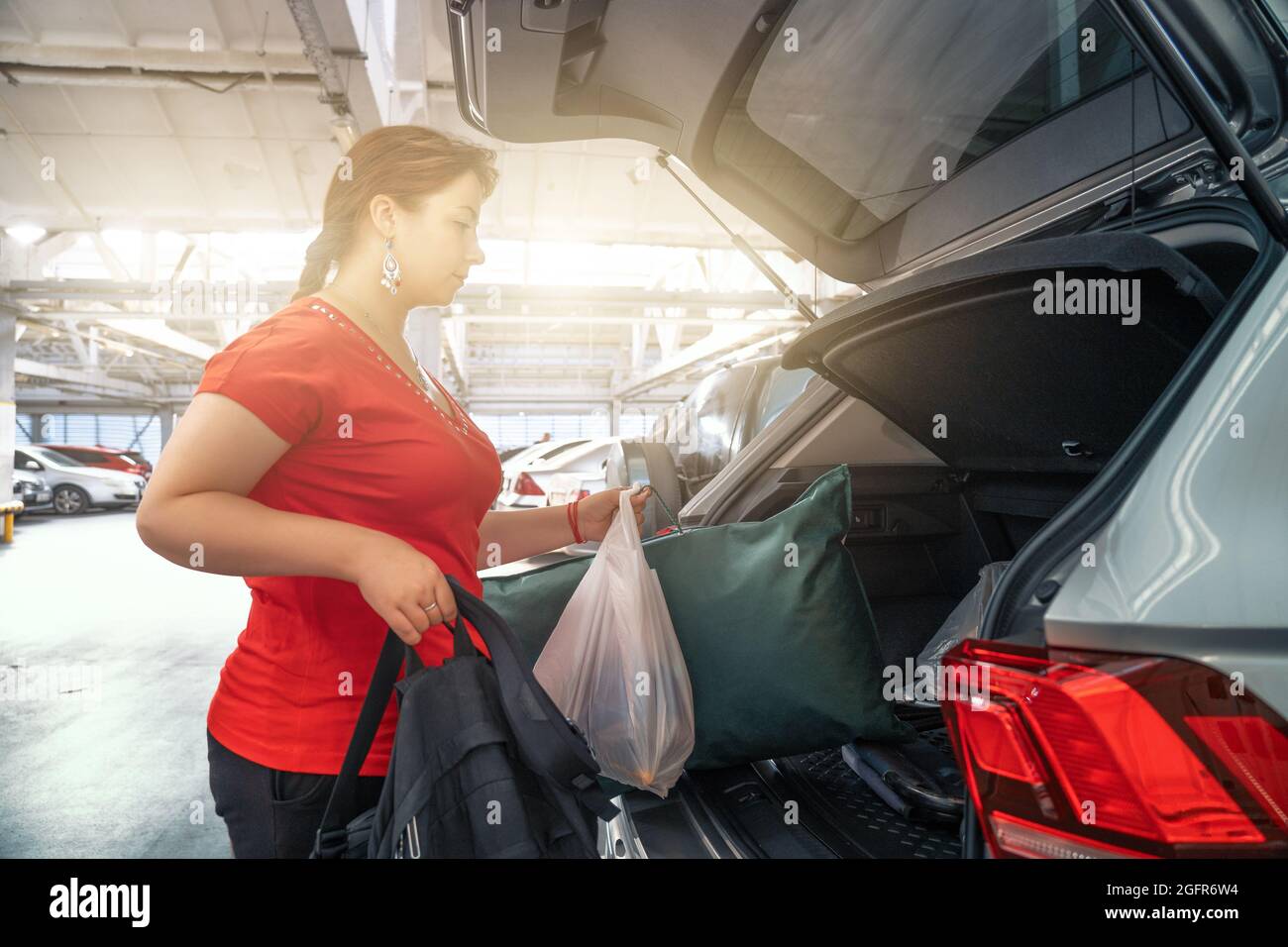 Young Girls After Shopping Loads Bags In Car Trunk In Mall Parking Lot Stock Photo Alamy