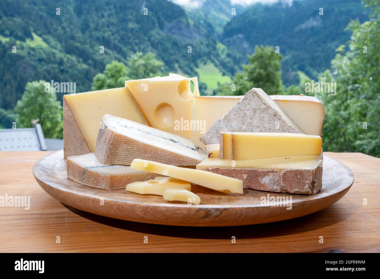 Cheese collection, wooden board with French cheeses comte, beaufort, abondance, emmental