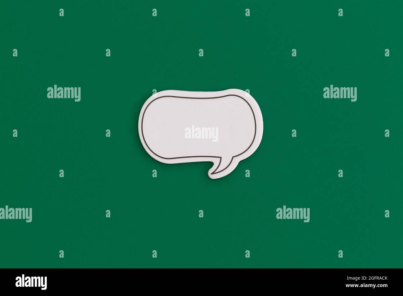 Paper speech bubble on a yellow background. Top view with copy space. Flat lay. Stock Photo