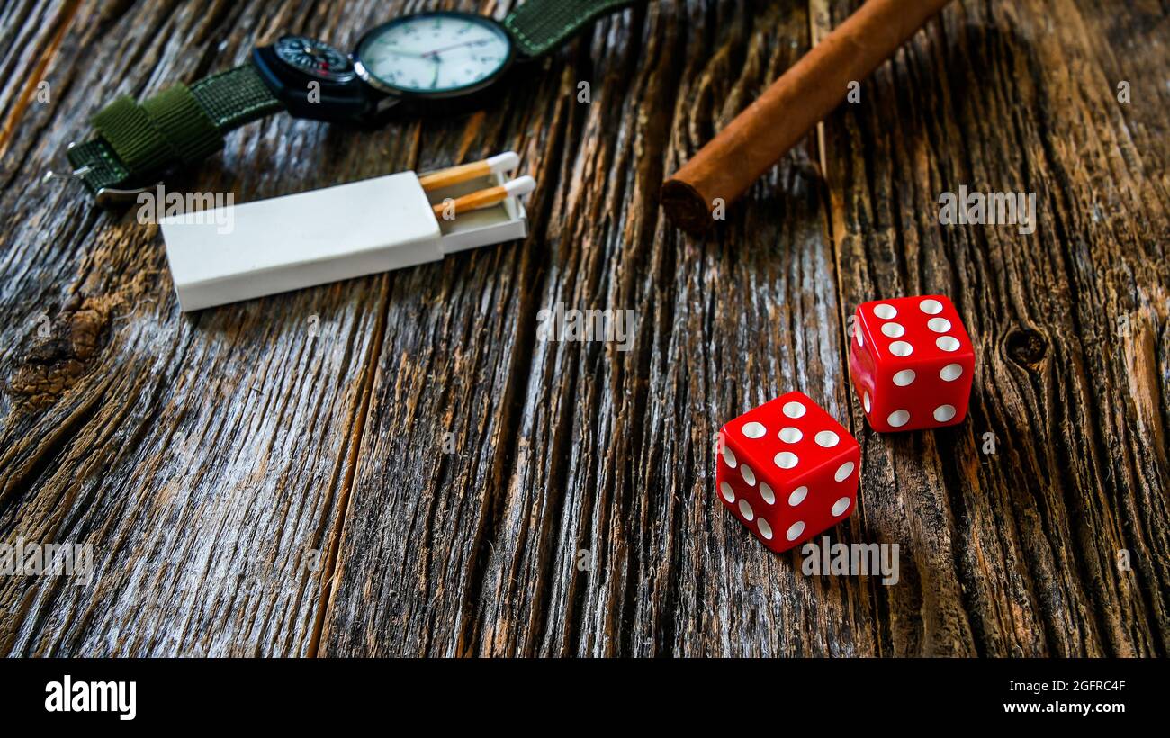 Two red dices on rustic old wooden table with other objects and text space Stock Photo