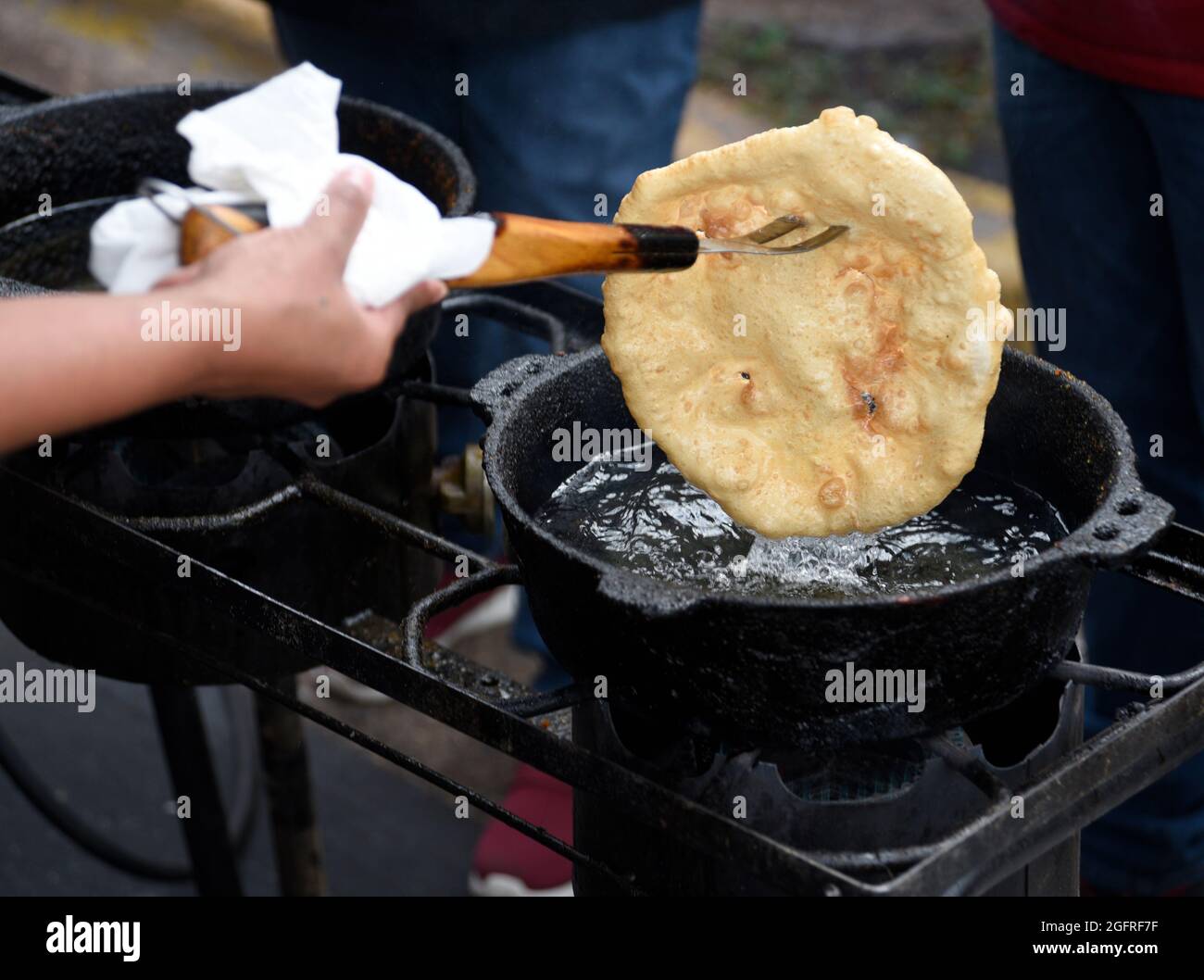 Native American volunteer cooks make Indian tacos or Indian fry bread  at an outdoor  food stand at the annual Santa Fe Indian Market in New Mexico. Stock Photo