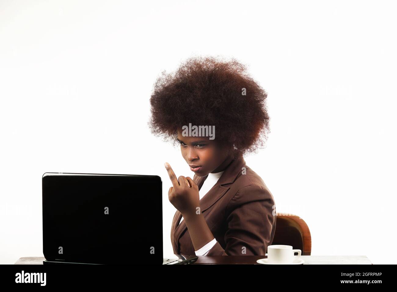 Young black Hispanic Latina business executive woman, with afro hair, with angry gesture looking at her laptop, in white background Stock Photo
