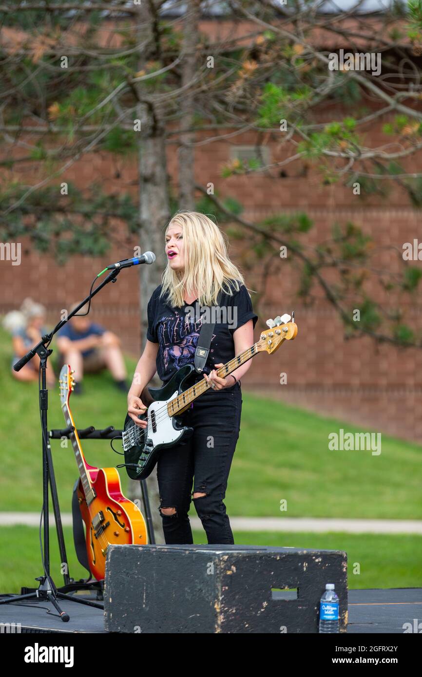 Melanie Morris, bass guitarist for the rock band Attaboy, plays and sings during an outdoor concert in Angola, Indiana, USA. Stock Photo