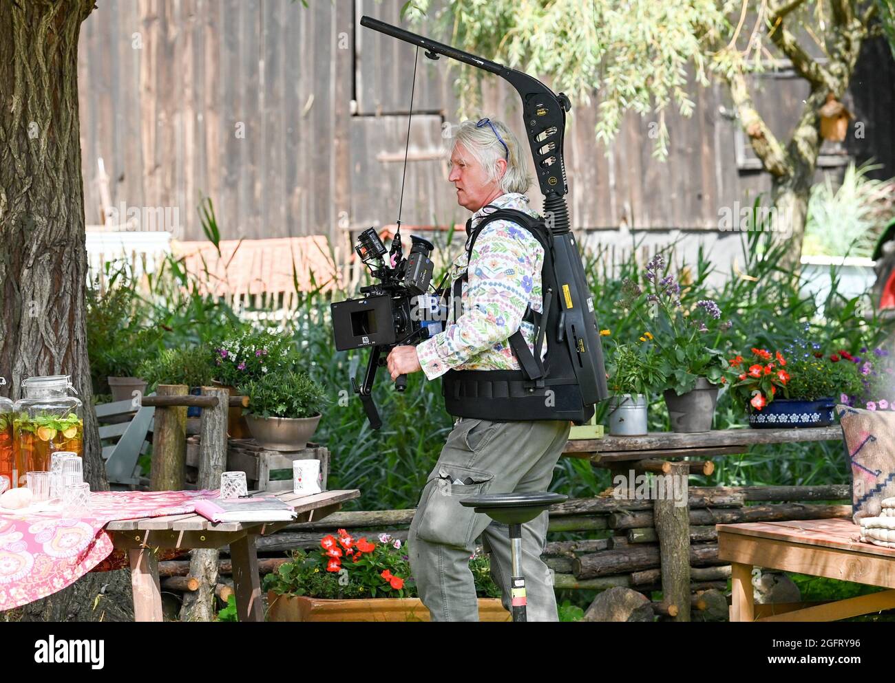 Berlin, Germany. 16th Aug, 2021. Director Detlef Buck strapped on a film camera during filming of 'Bibi & Tina - Einfach Anders' at Martinshof and shot a scene himself. Shooting of the new feature film directed by Detlev Buck began at the end of July. Filming is taking place in Berlin, Brandenburg and Saxony-Anhalt. Credit: Jens Kalaene/dpa-Zentralbild/dpa/Alamy Live News Stock Photo