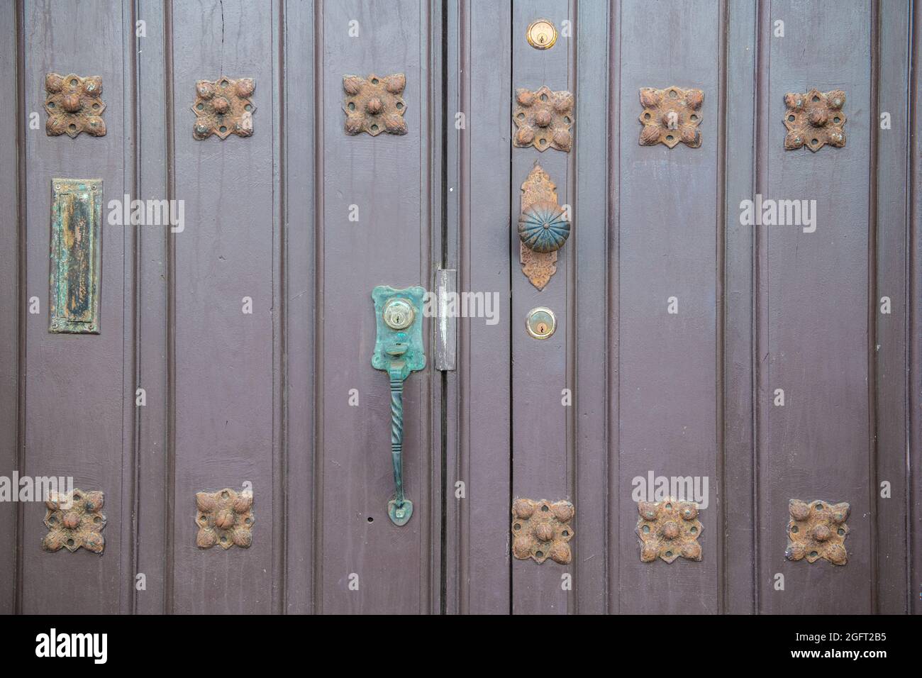 A set of wooden doors adorned with metal ornaments - Puerto Rico Stock Photo