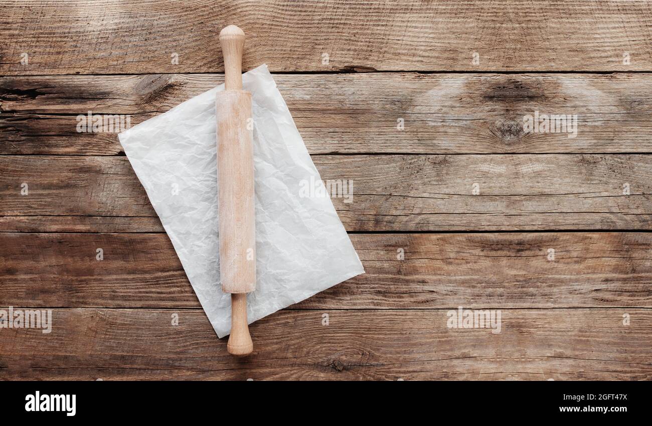 Ingredients for baking and kitchen utensils on old wooden background. Cooking baking dough, preparing flour, rocking pin, parchment paper. Baking conc Stock Photo