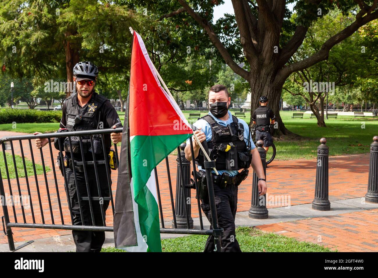 Washington, DC, USA, 26 August, 2021.  Pictured: A Secret Service officer and US Park Police officer set up a barricade after ordering Palestinians and supporters to leave Lafayette Park during a protest against Naftali Bennett’s first visit to the White House as prime minister of Israel.  The order to leave is highly unusual, as Secret Service allows protests in the park every day.  Credit: Allison Bailey / Alamy Live News Stock Photo