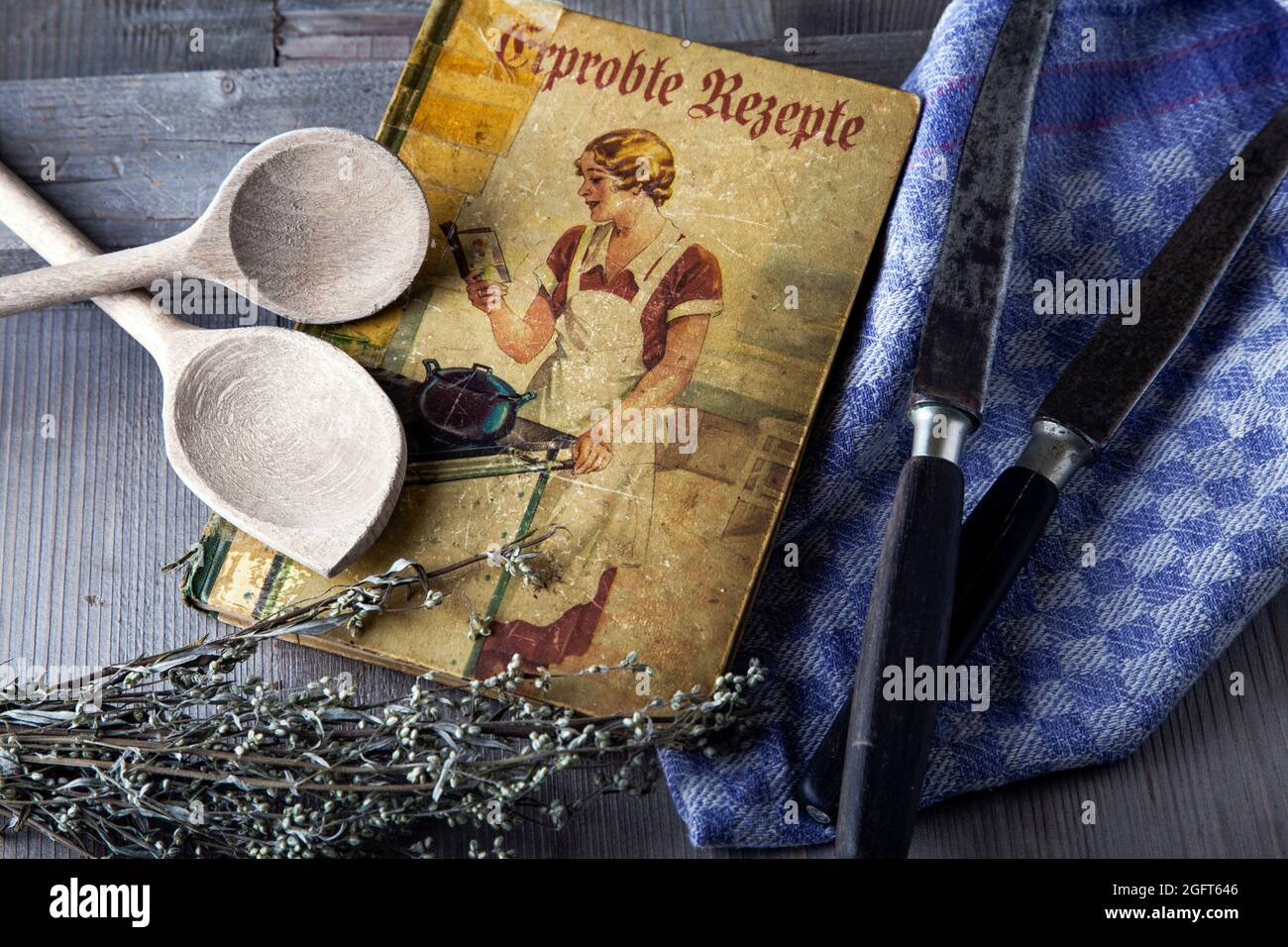 antique cookbook with wooden spoon and knife Stock Photo