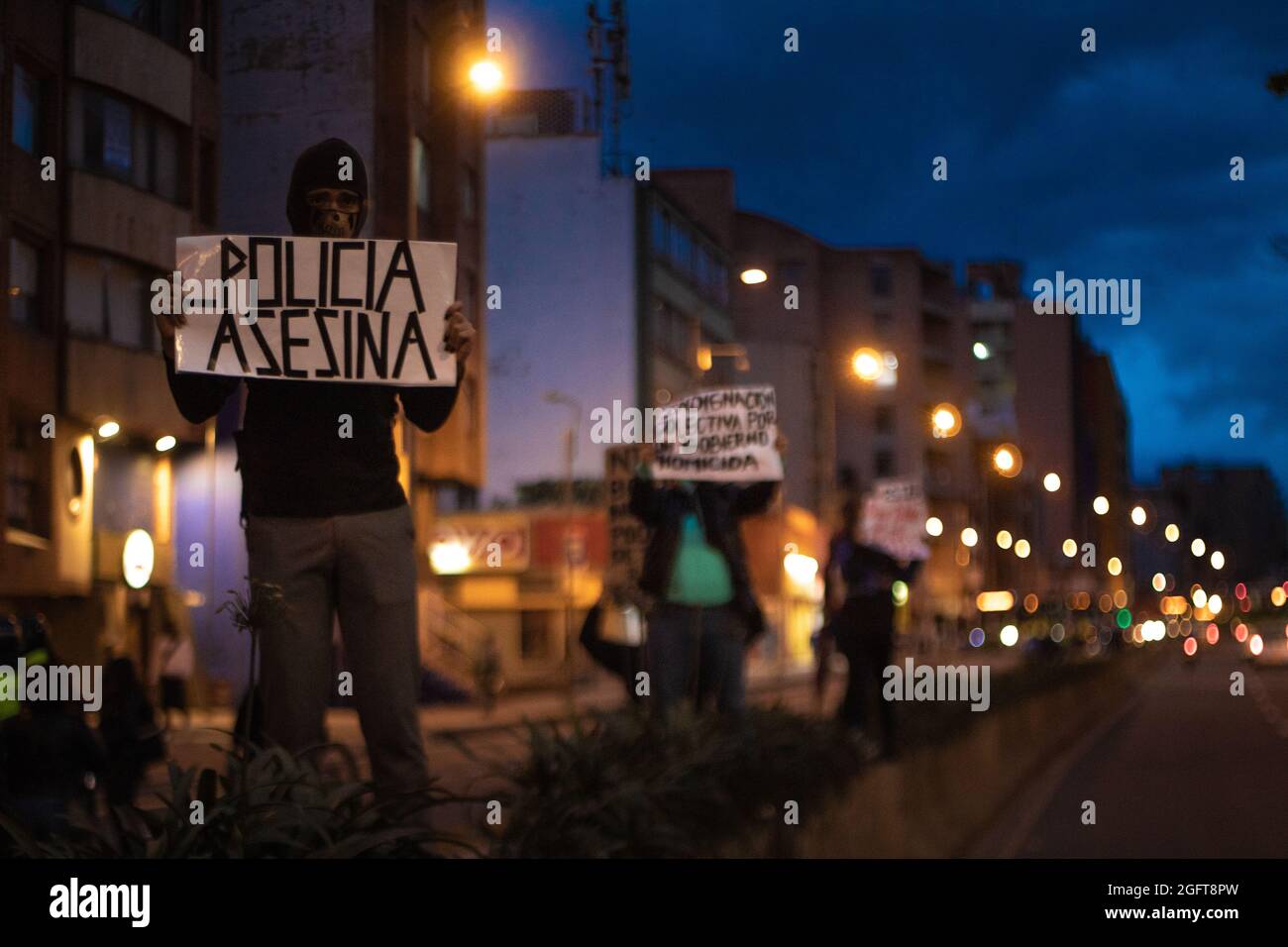 Demonstrators hold signs against police brutality during a rally organized by students of the Universidad Distrital, after a few days back Esteban Mosquera, a social leader and community member was killed two years after loosing his eye on a police brutality case, in Bogota, Colombia on August 26, 2021. Stock Photo