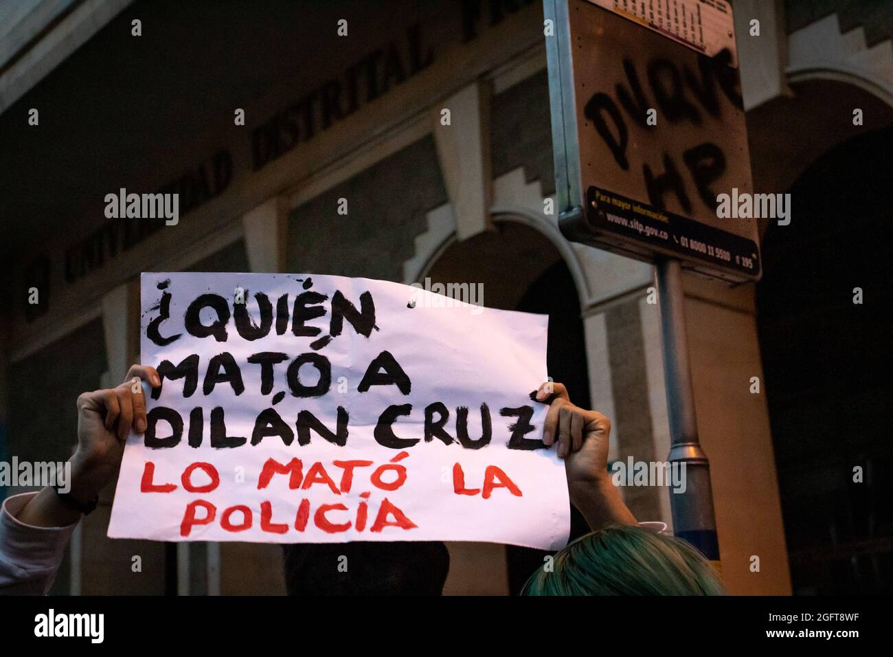 A demonstrator rises a banner that reads 'Who Killed Dilan Cruz? Police did' during a rally organized by students of the Universidad Distrital, after a few days back Esteban Mosquera, a social leader and community member was killed two years after loosing his eye on a police brutality case, in Bogota, Colombia on August 26, 2021. Stock Photo