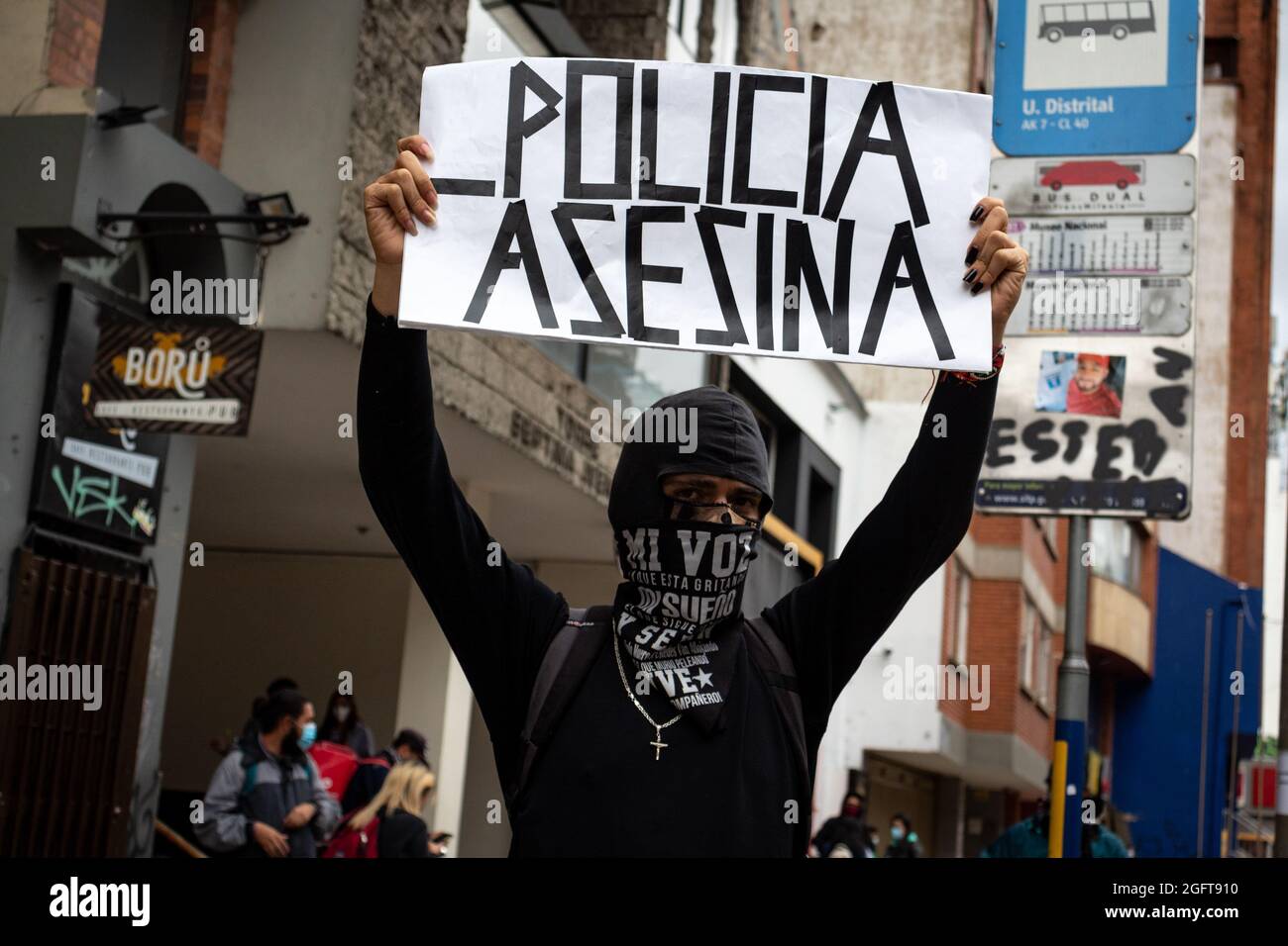 A demonstrator rises a banner that reads 'Killer Police' during a rally organized by students of the Universidad Distrital, after a few days back Esteban Mosquera, a social leader and community member was killed two years after loosing his eye on a police brutality case, in Bogota, Colombia on August 26, 2021. Stock Photo