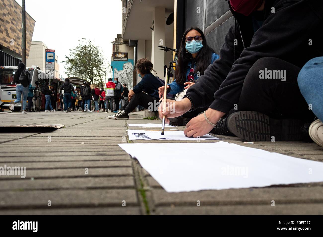 Demonstrators make signs and banners against police brutality during a rally organized by students of the Universidad Distrital, after a few days back Esteban Mosquera, a social leader and community member was killed two years after loosing his eye on a police brutality case, in Bogota, Colombia on August 26, 2021. Stock Photo