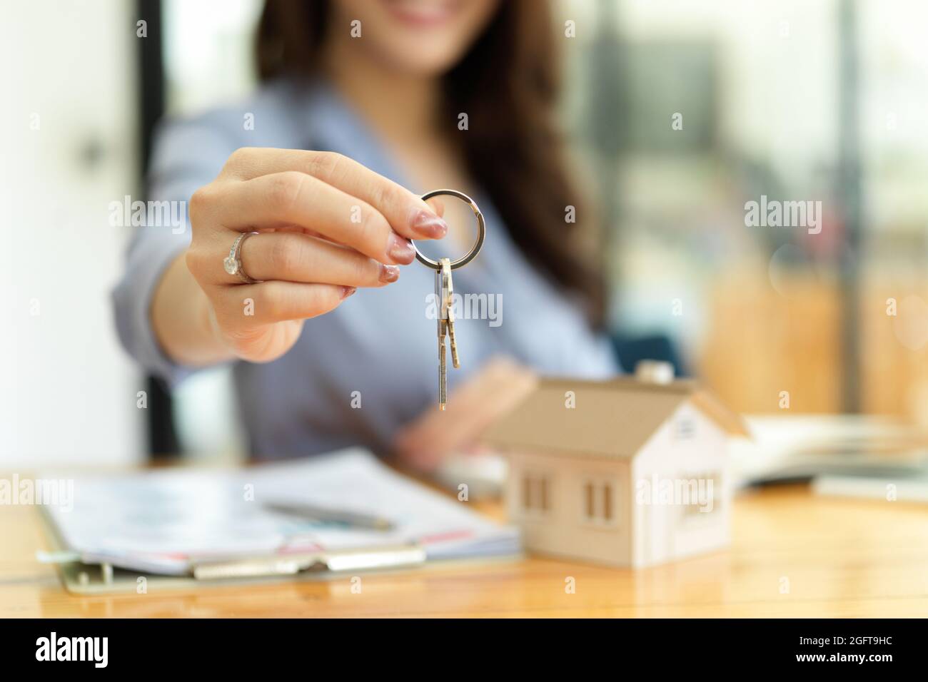 Female residential broker, real estate agent holding house keys in hand ...