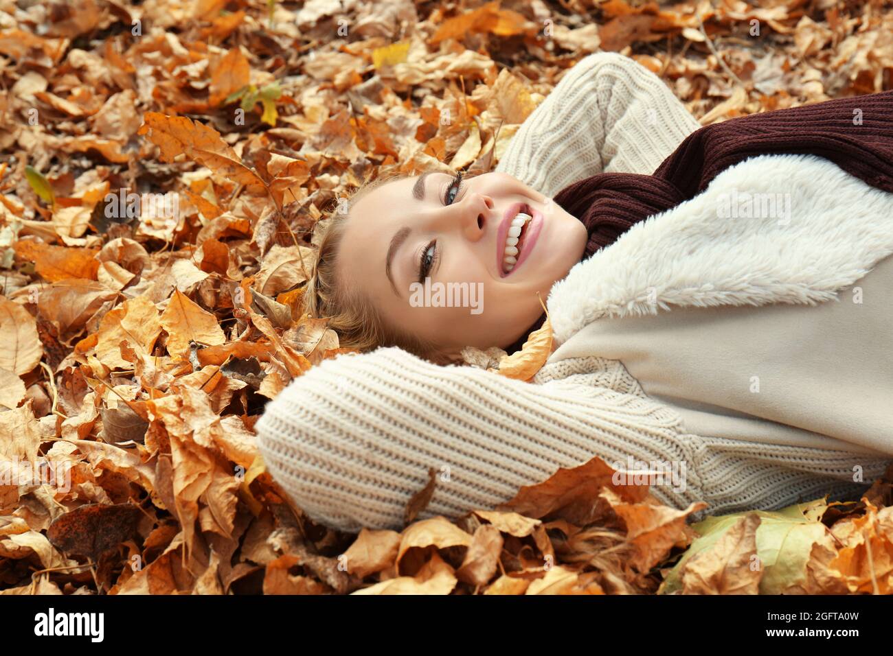 Beautiful girl lying on leaves in autumn park Stock Photo - Alamy