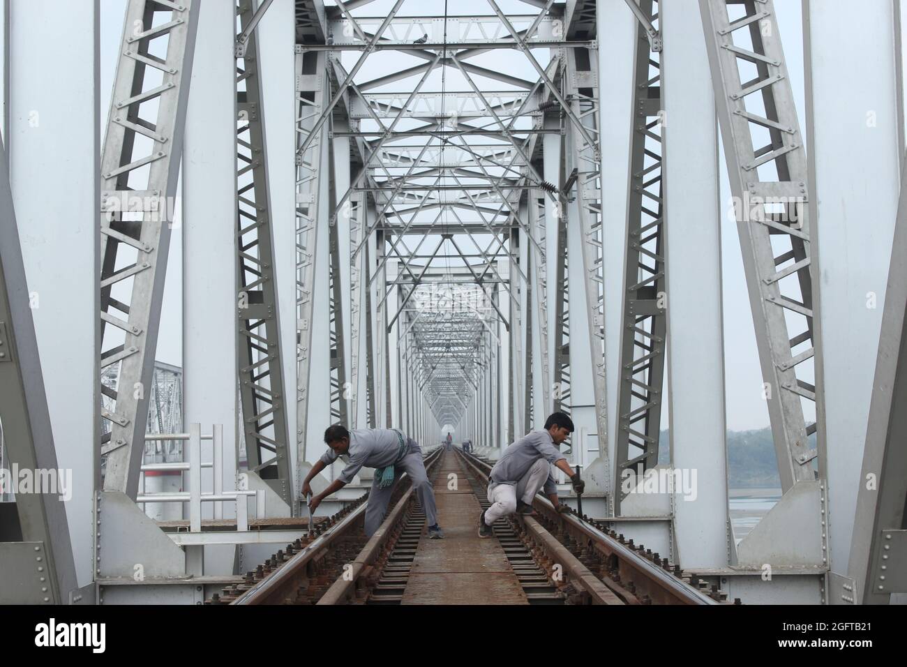 The bridge of  Indian Railways in Bihar, and railway workers working on the track. Stock Photo