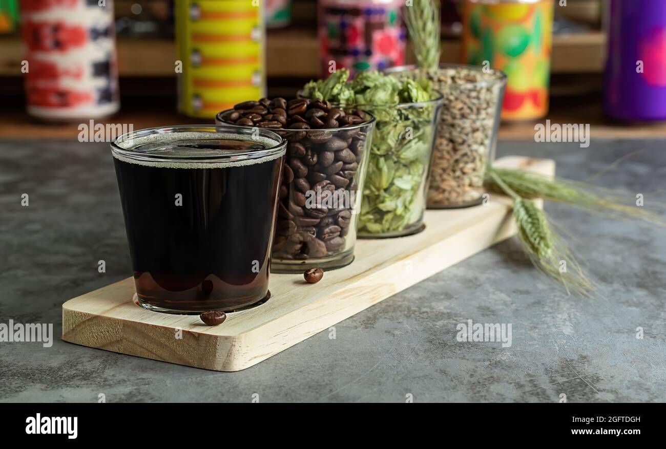 Coffee stout with ingredients. Wooden board for flight set craft beer tasting Stock Photo
