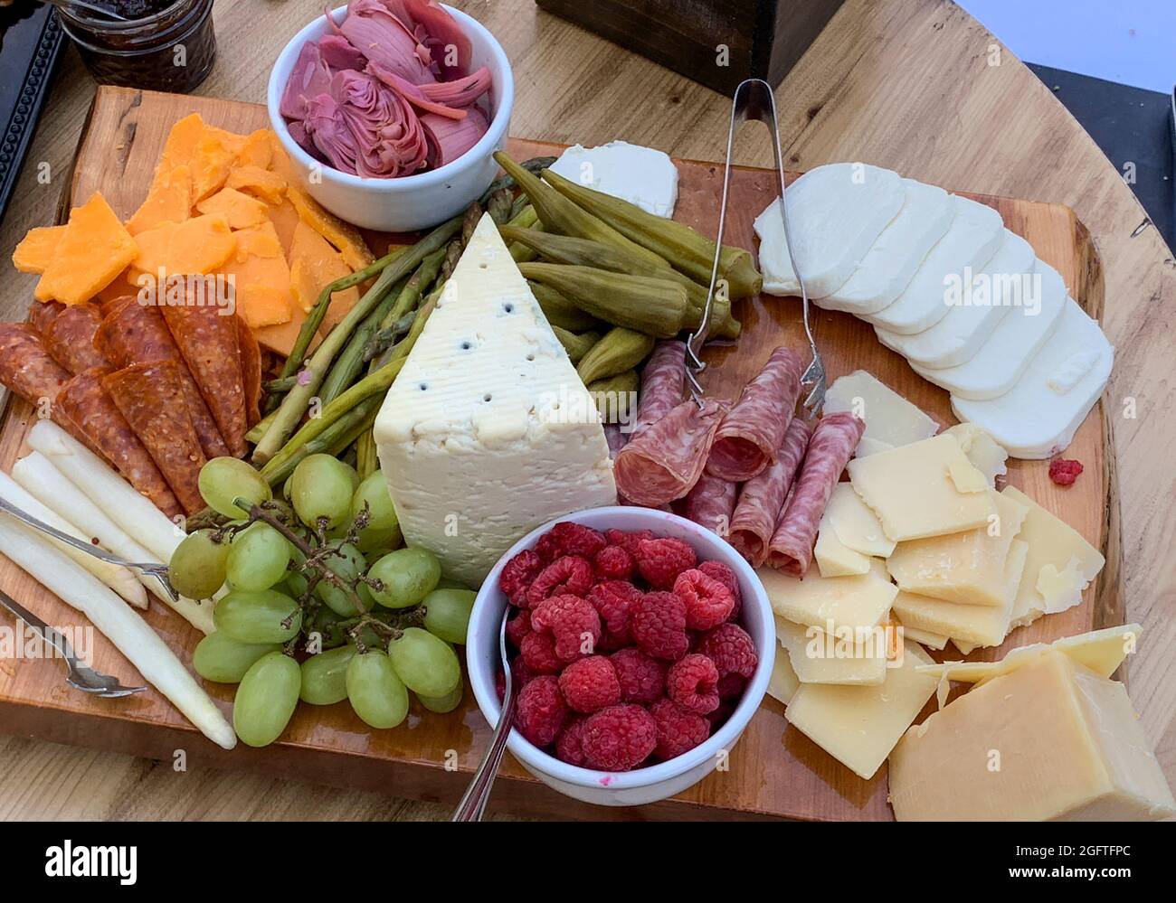 Appetizer Board at a Buffet.  Cheeses, Raspberries, Grapes, Ham. Stock Photo