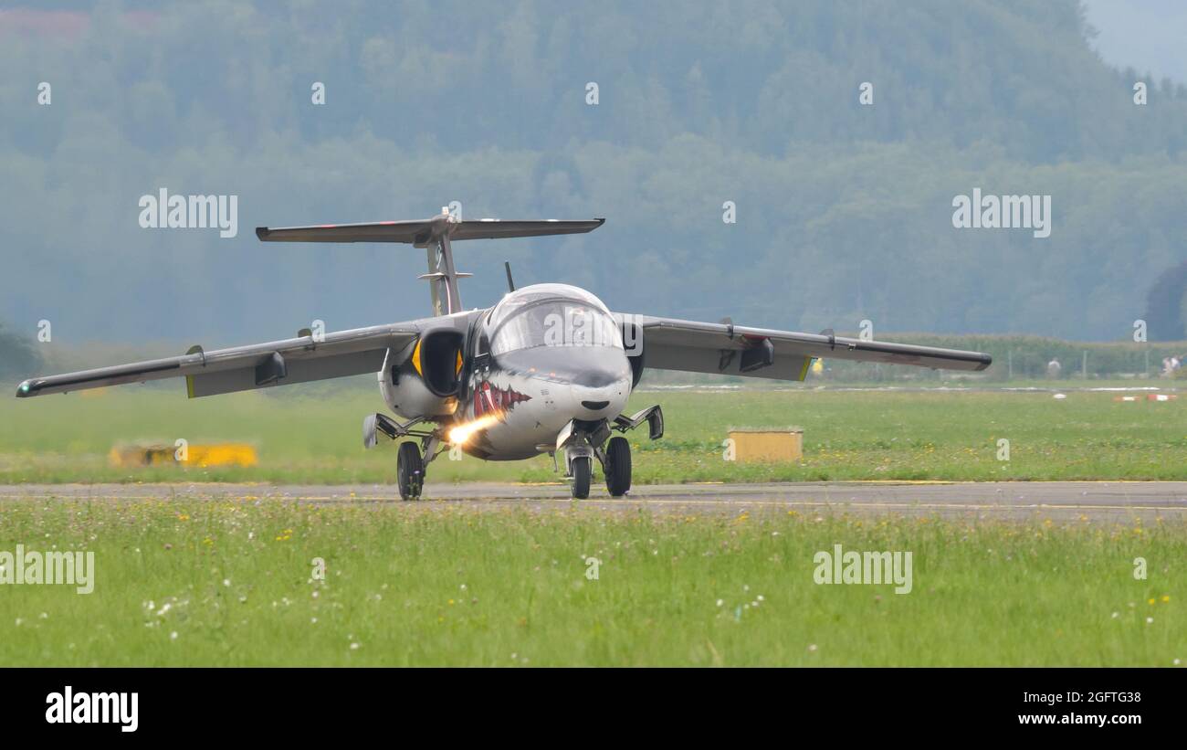 Zeltweg, Austria SEPTEMBER, 6, 2019 Military jet airplane taxiing on the runway with lights on in a green background. SAAB 105 of Austrian Air Force Stock Photo