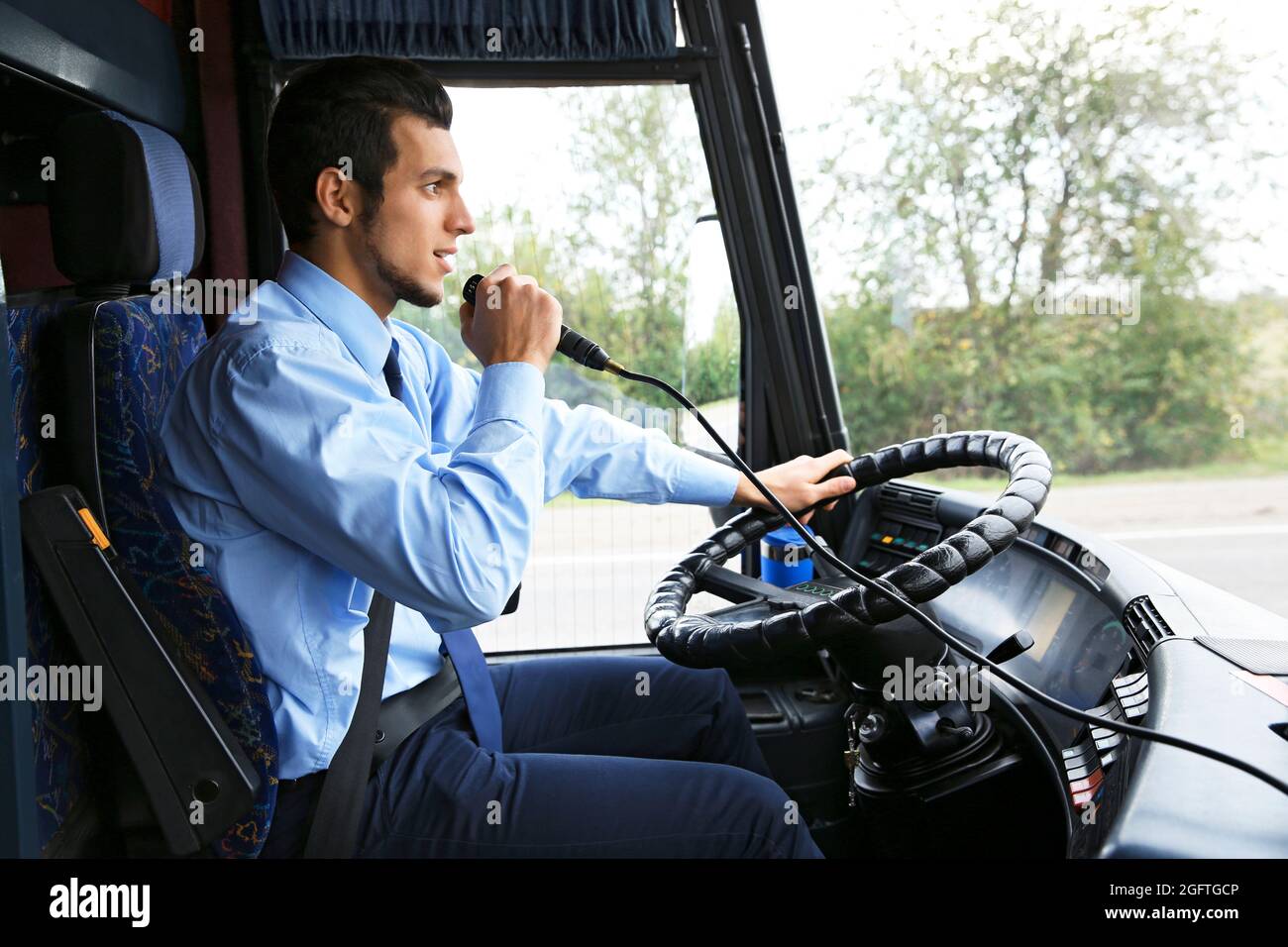 Handsome driver using microphone in bus Stock Photo Alamy
