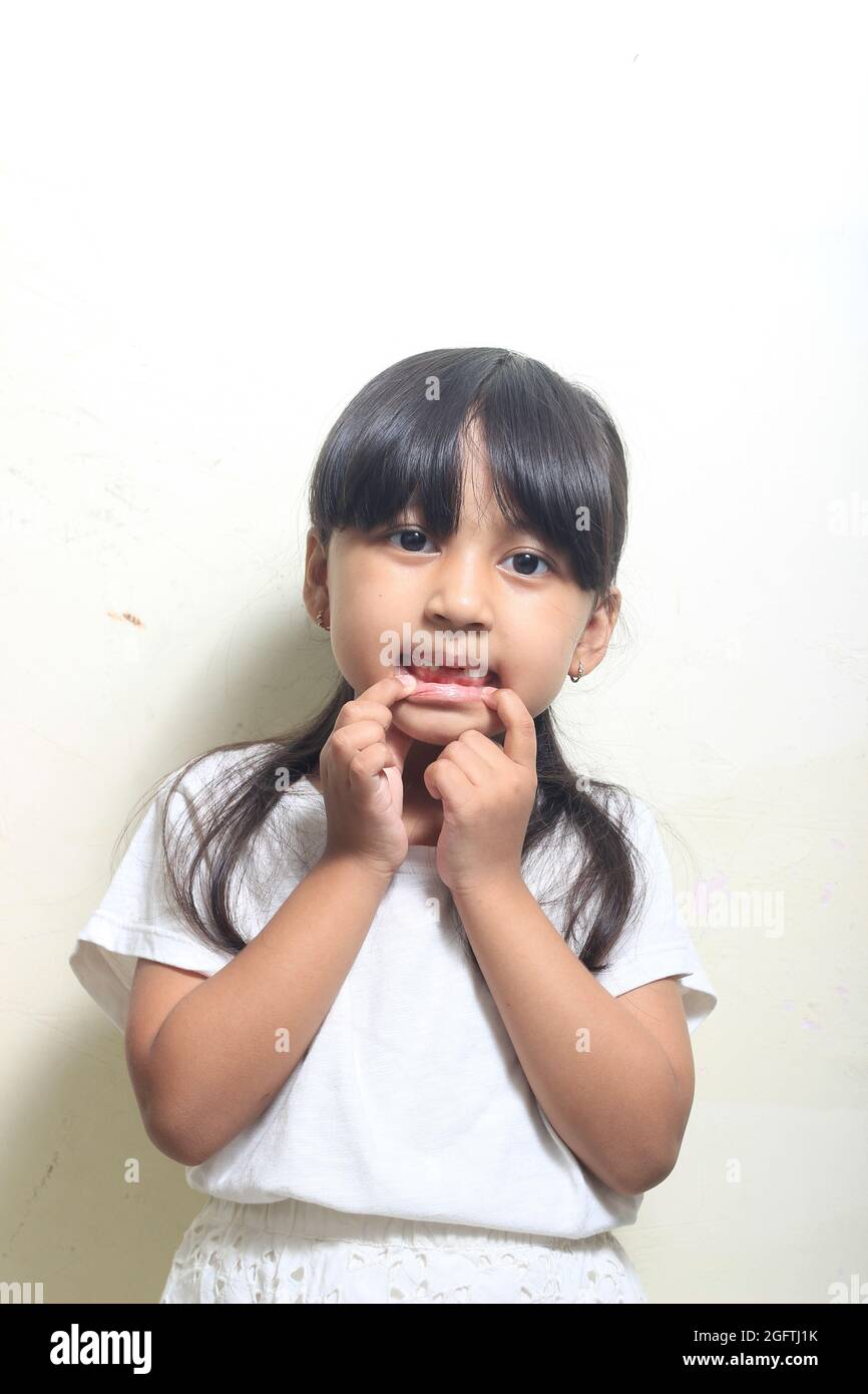 Photo Studio Indoor, Girl Showing her loose teeth Stock Photo