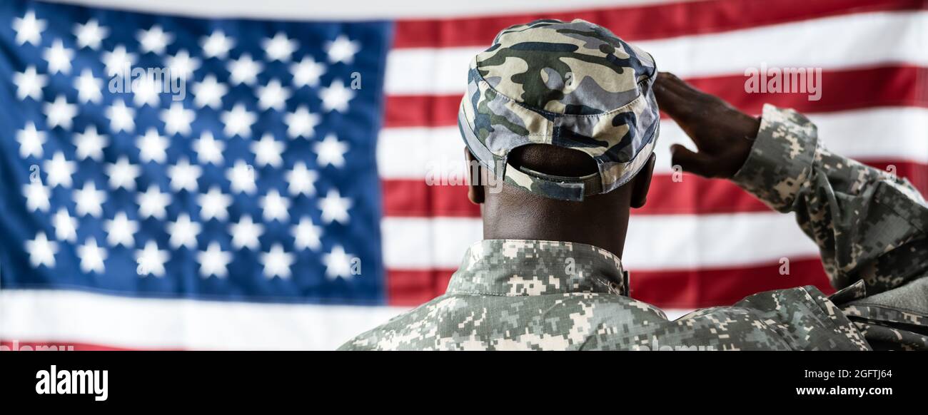 African American Army Soldier Saluting In Front Of American Flag Stock Photo