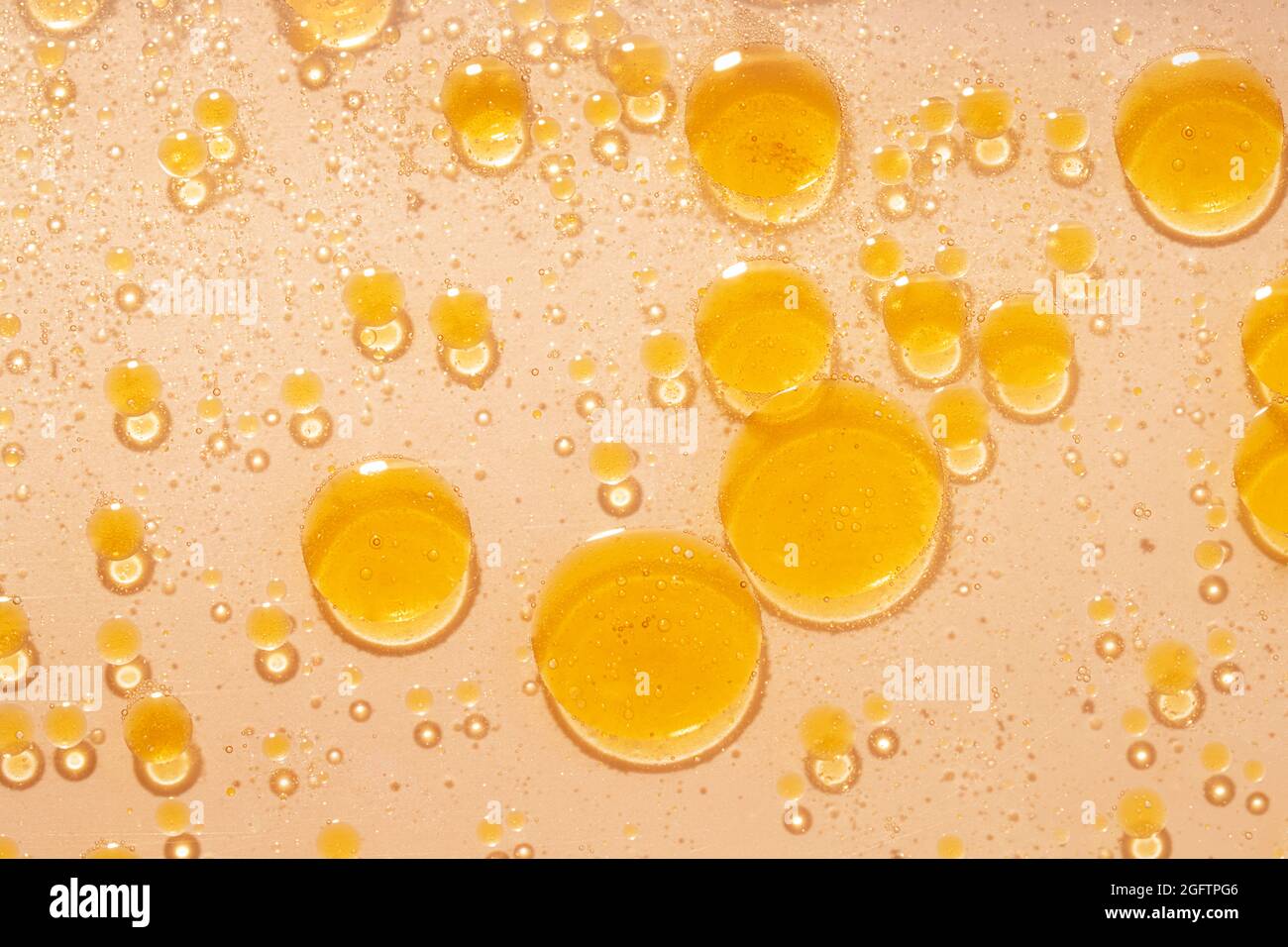 Abstract oil bubble background. Orange color oil, close-up top view. Stock Photo