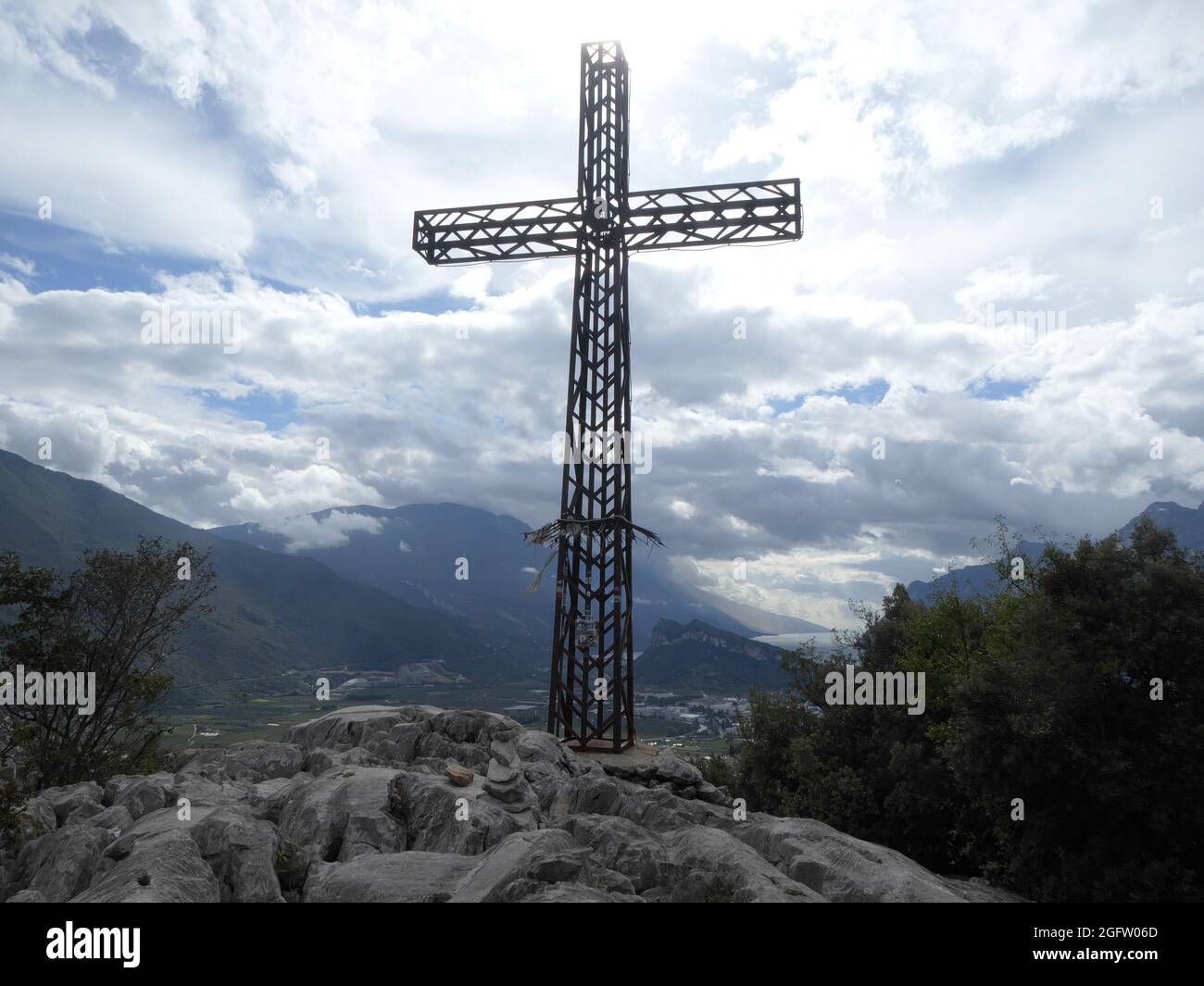 Steely summit cross of Monte Colodri with view of lake Garda Stock Photo