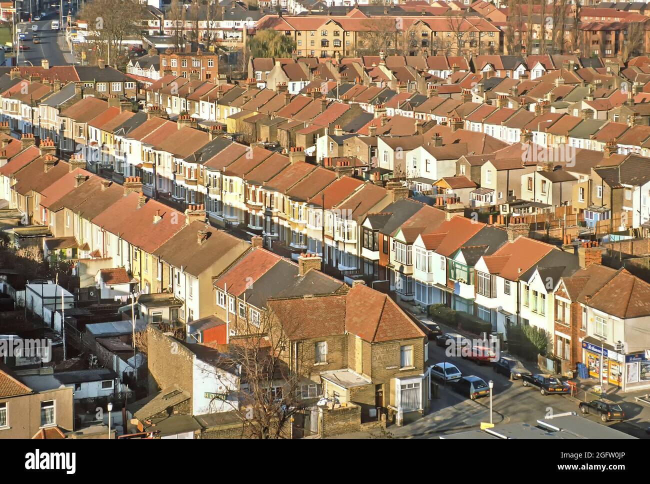 Archive 1989 winter sunshine in aerial view of 1980s roof tops on terraced housing blocks with small back gardens in straight line streets full of parked cars in this densely populated 80s archival image of an urban landscape in the town of Barking in East London borough of Barking and Dagenham England UK Stock Photo
