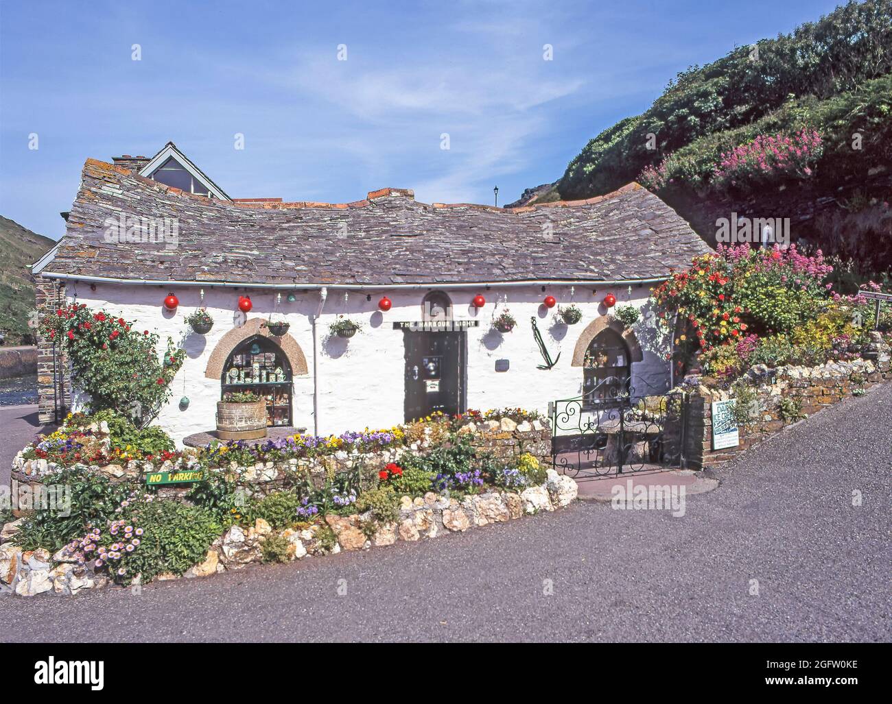 Archive view of picturesque1996 historical 1990s riverside Grade II Listed Building The Harbour Light Pixie souvenir shop with garden flowers converted from stables opening as a touristy gift shop beside River Valency seen on left later destroyed in 2004 flood & rebuilt as tea room an archival image from the way we were in the 90s in Boscastle Cornwall England UK Stock Photo