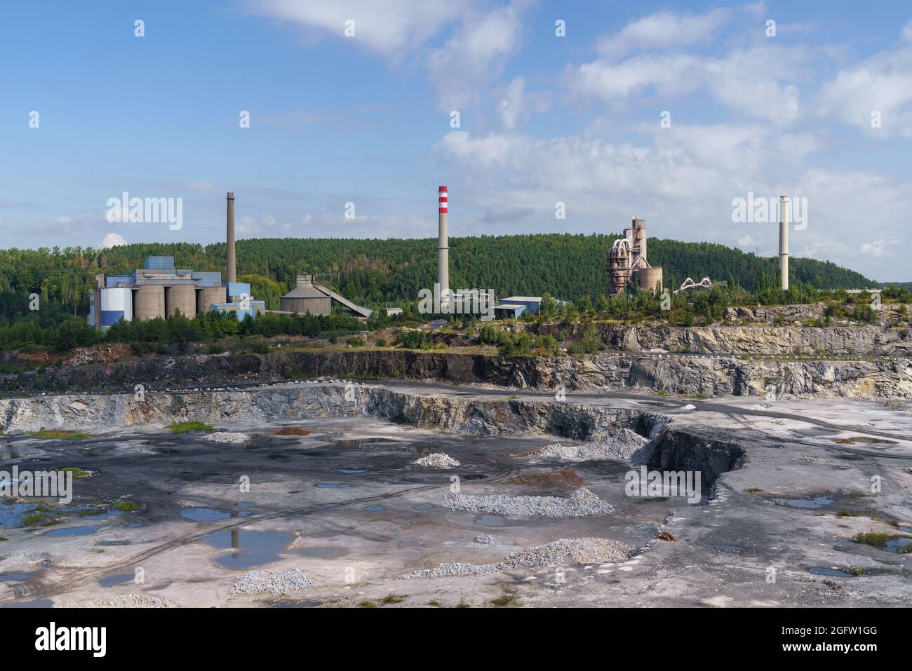 Opencast mining quarry with machinery and mining equipment. Limestone mining for cement production. Stock Photo