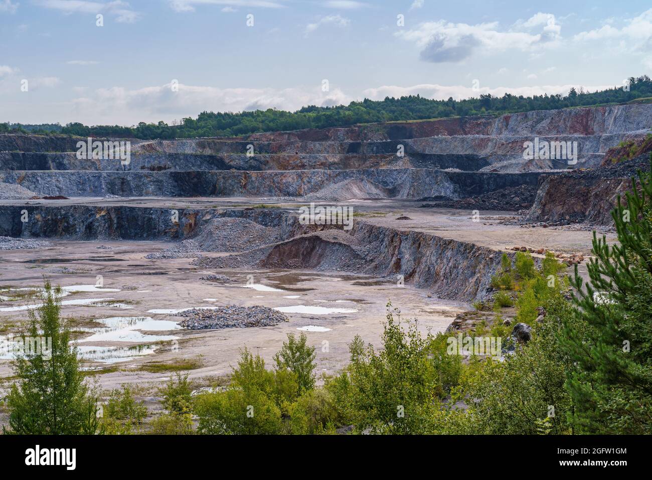 Opencast mining quarry with machinery and mining equipment. Limestone mining for cement production. Stock Photo